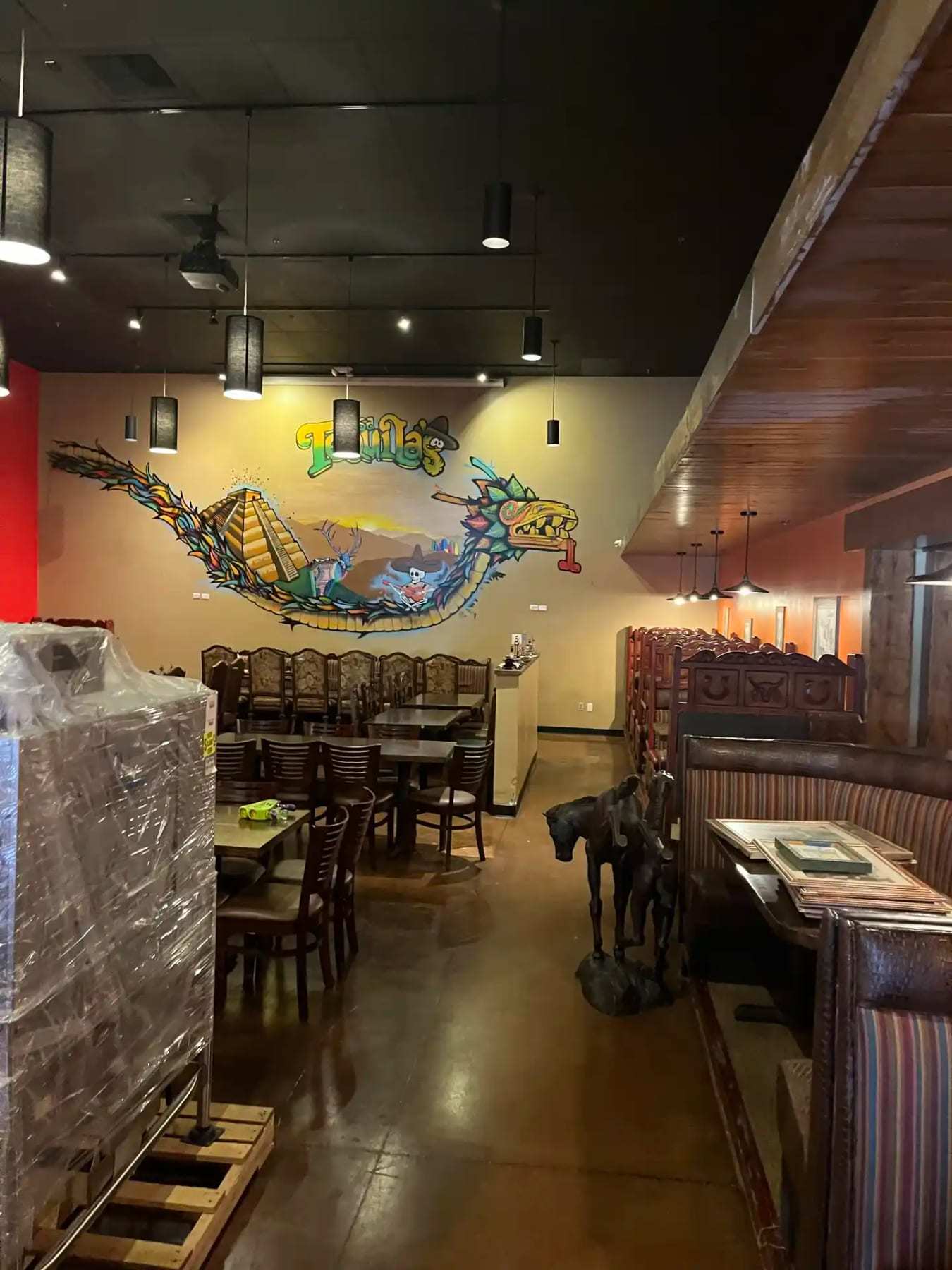 Restaurant dining area with a wall mural and contents wrapped on pallets